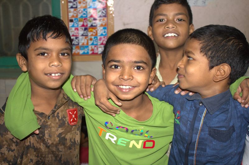 Four children smiling together during an India mission visit