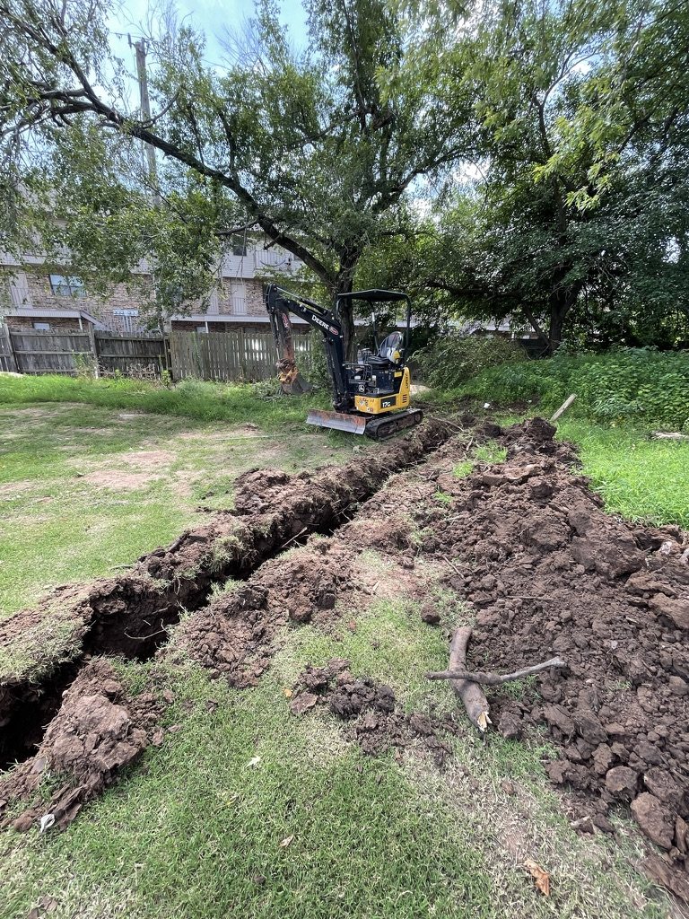 Open drainage trench with a compact excavator during yard work