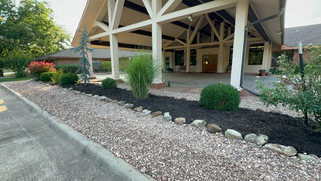 Rock groundcover, stone edging and trimmed shrubs beside the Christian Villa entrance