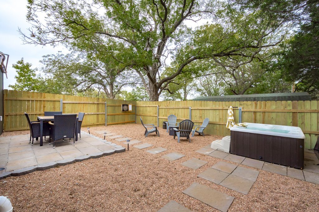 Small path lights beside stepping stones, gravel and a backyard seating area