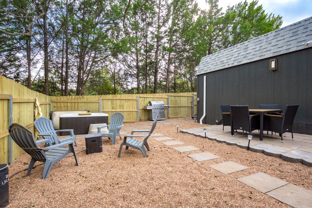 Gravel backyard seating area with stepping stones and wood privacy fencing