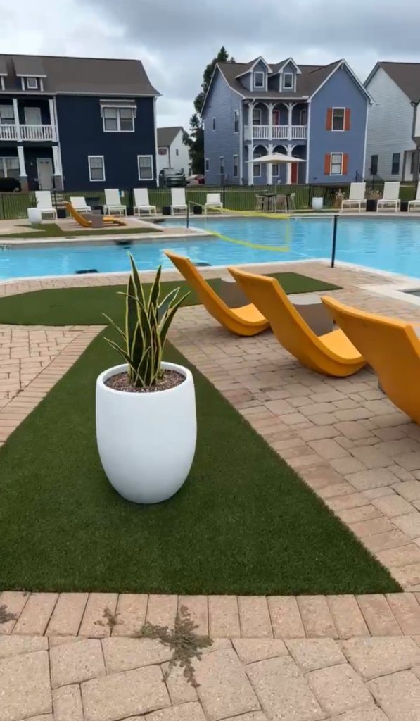 Artificial turf beside pool paving and lounge furniture at Cottage Row