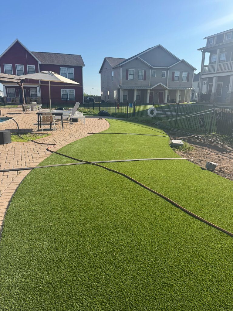 Artificial turf alongside black fencing and paver paths at Cottage Row